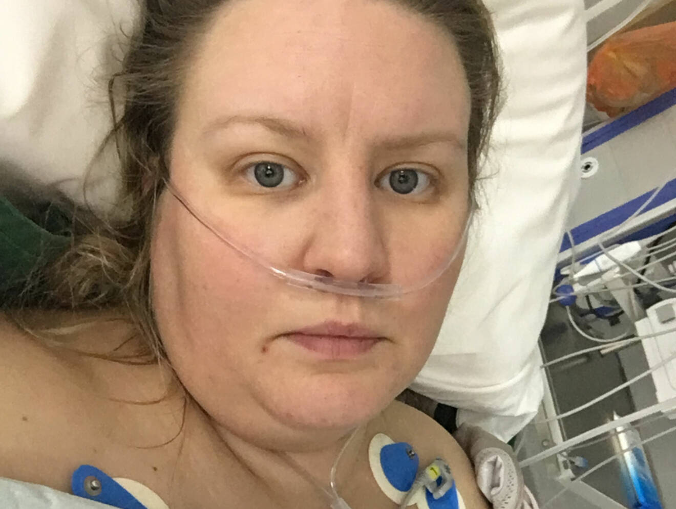 Heidi Mattsson ligger i en sjukhussäng och tittar in i kameran.