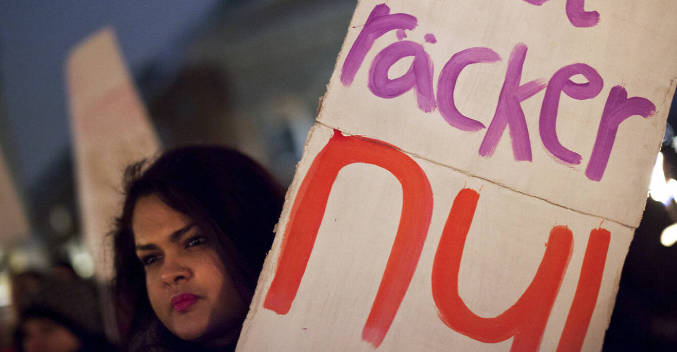 En kvinna håller upp en skylt med texten: Det räcker nu för att protestera mot mäns våld mot kvinnor