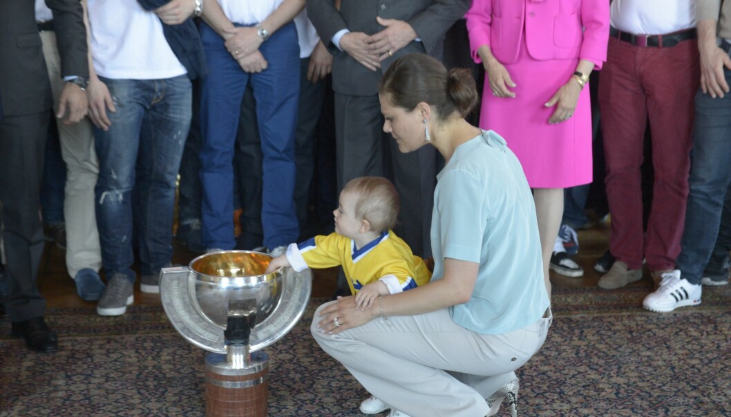 Foto: Bertil Enevåg Ericson/TT Prinsessan Estelle sträcker sig och tar tag i guldpokalen från ishockey VM 2013.