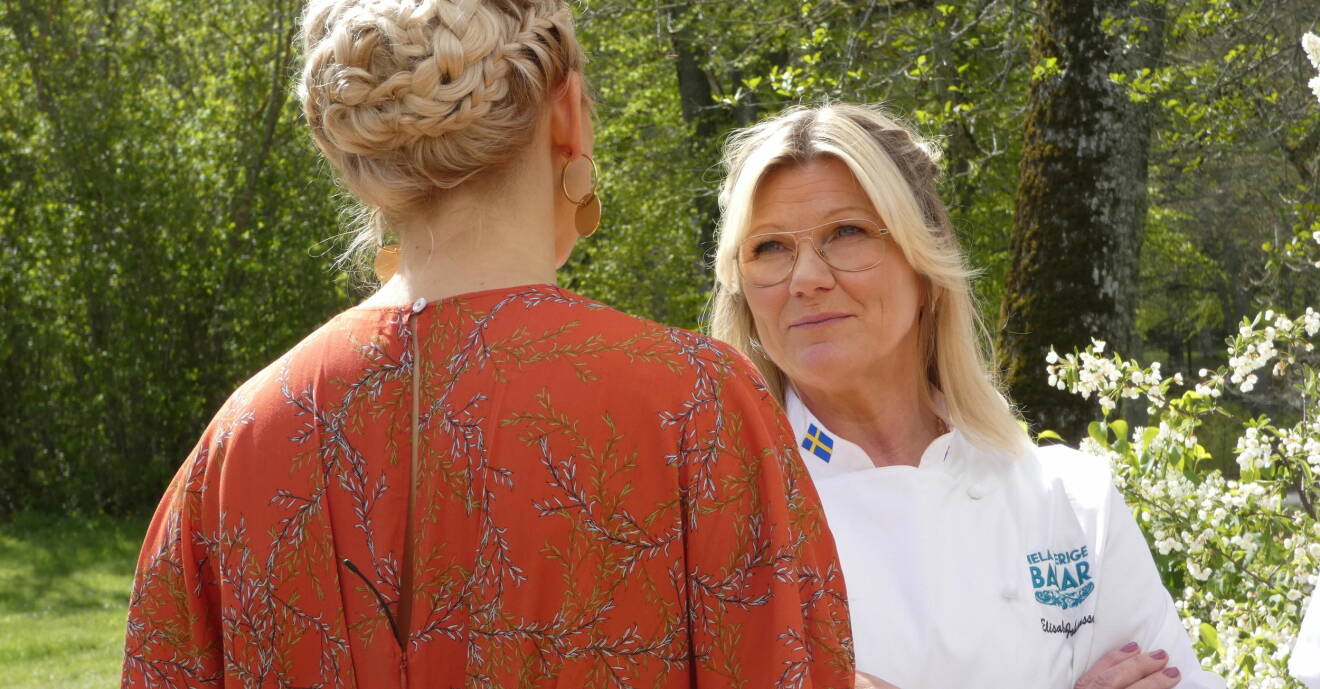 Elisabeth Johansson står och pratar med Tina Nordström, som är vänd med ryggen mot kameran, under inspelningarna av Hela Sverige bakar sommaren 2020.