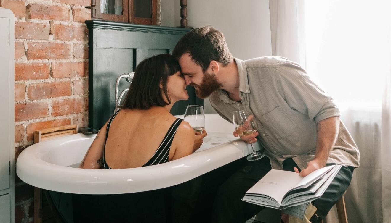 Ett par lutar kärleksfullt ansiktena mot varandra i ett badkar.