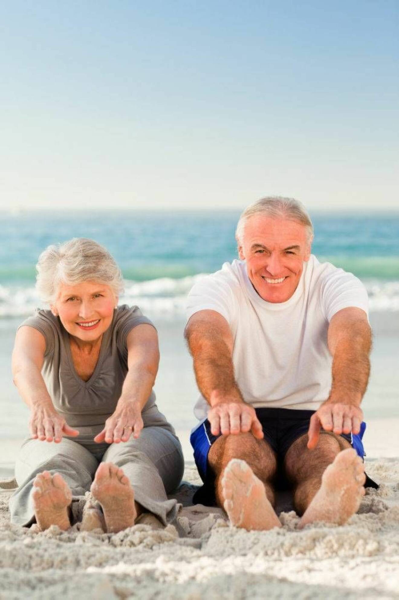 Äldre par gympar på strand.