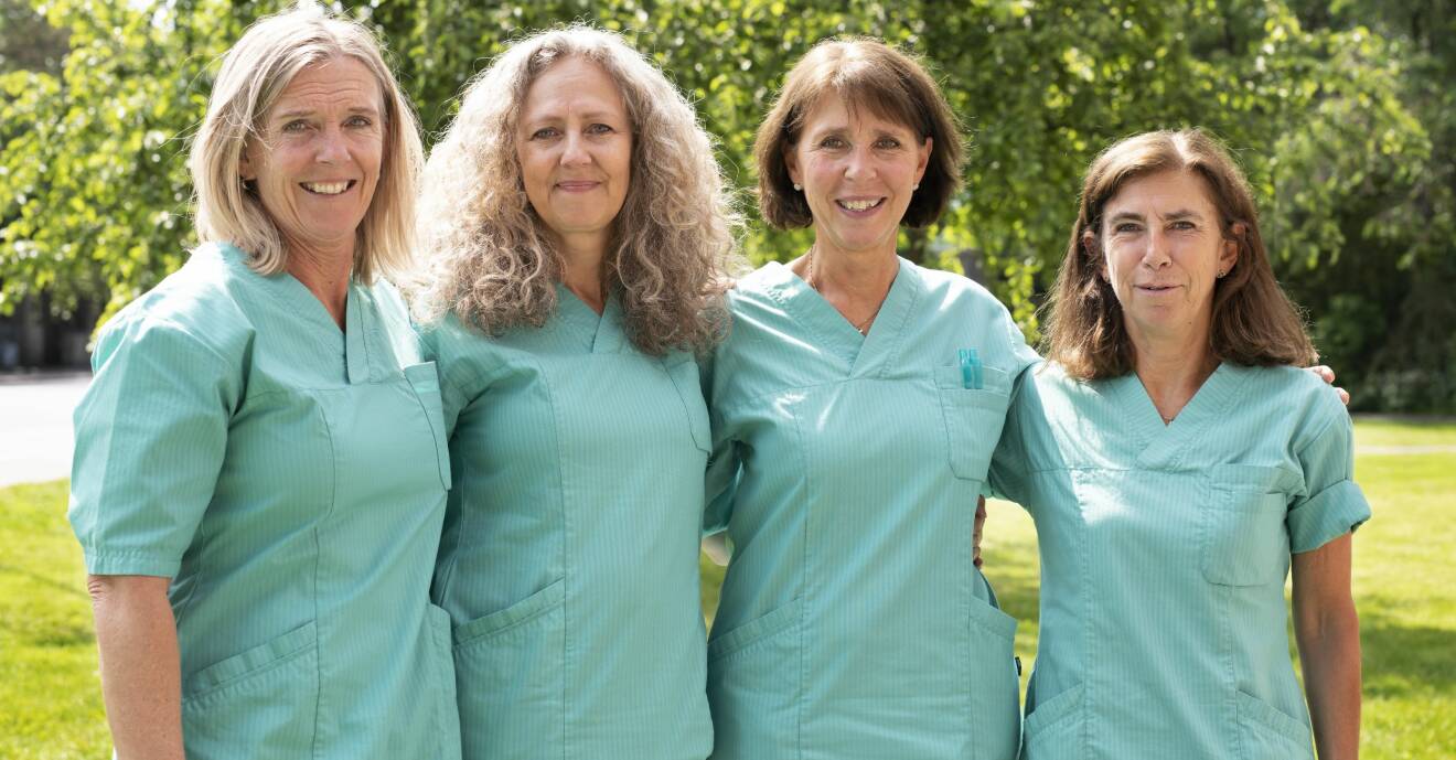 Fyra kvinnor i sjukvårdskläder utomhus.