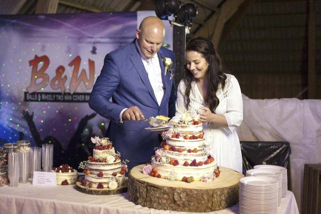Petra och Sebastian skär upp bröllopstårtan