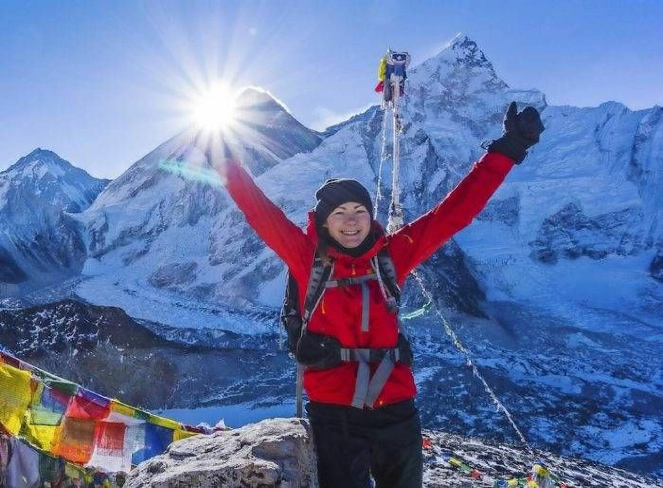 En glädjerusig Ida på bergstoppen Kala Patthar i Himalaya.