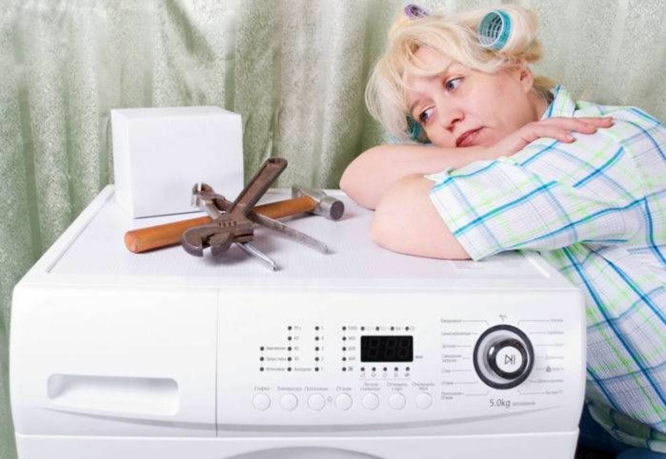 Kvinna som reparerar en tvättmaskin
