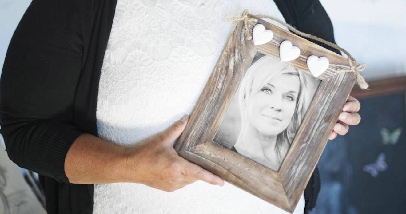 Camilla Rudholm håller upp ett porträtt av sin mördade syster Lotta Rudholm. 