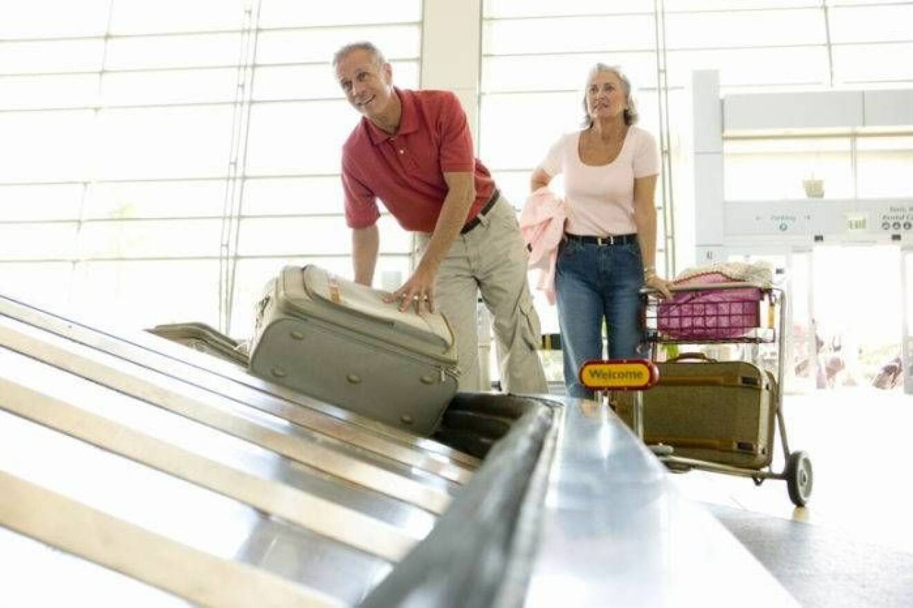 Resenärer får sitt bagage på flygplatsen.