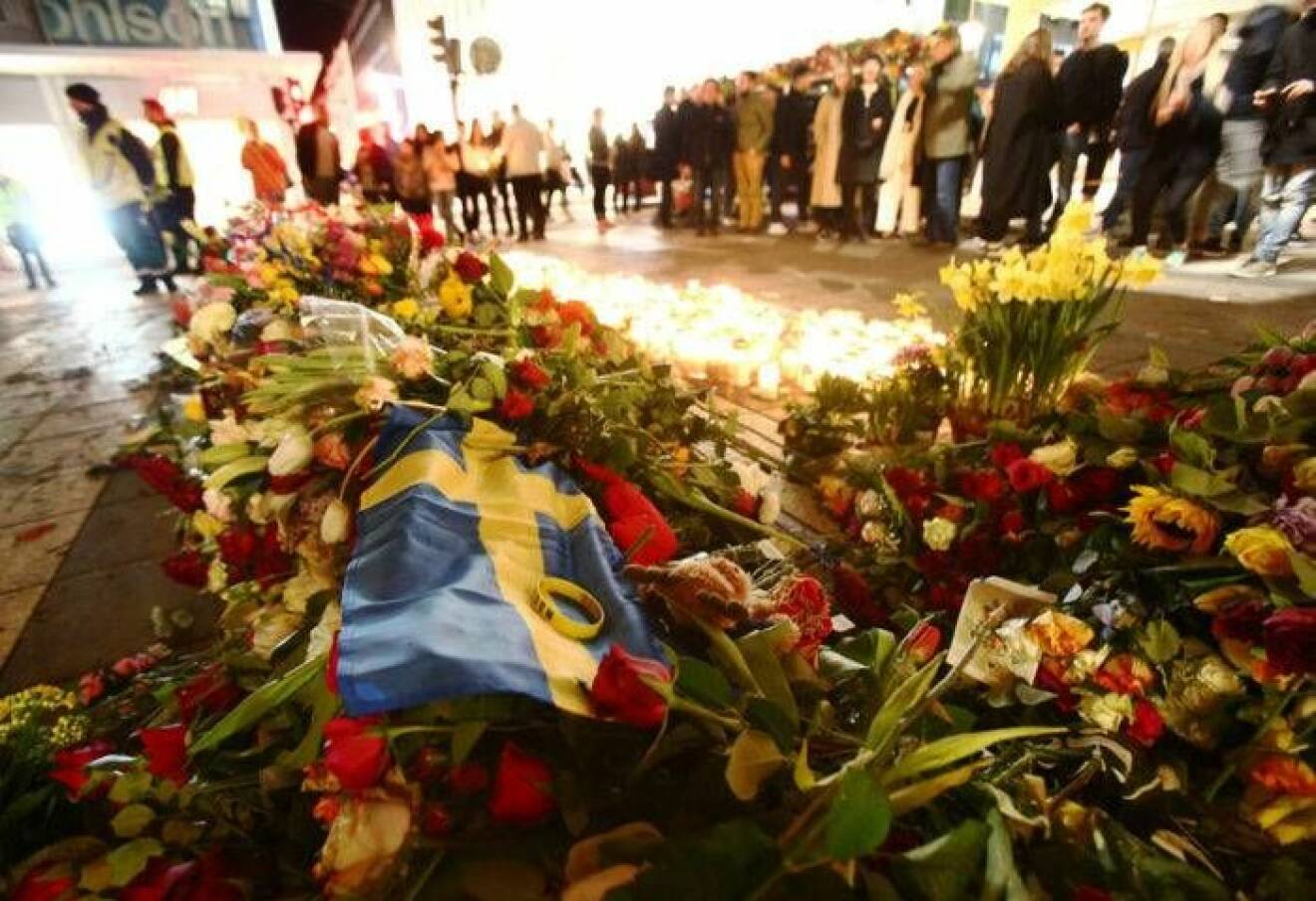 Blommor på platsen vid Åhlens i Stockholm där terrordådet inträffade.