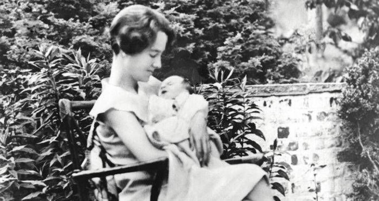 Anne Morrow Lindbergh sitter i en stol utomhus med lille Charles Lindbergh Jr.