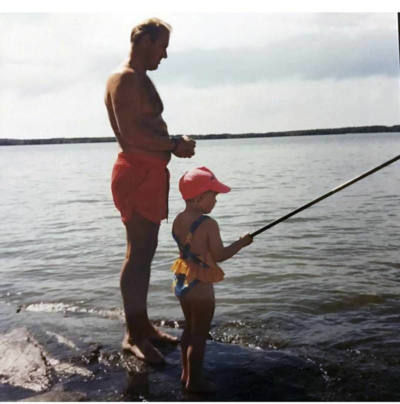 Elisa som barn när hon fiskar med pappa.