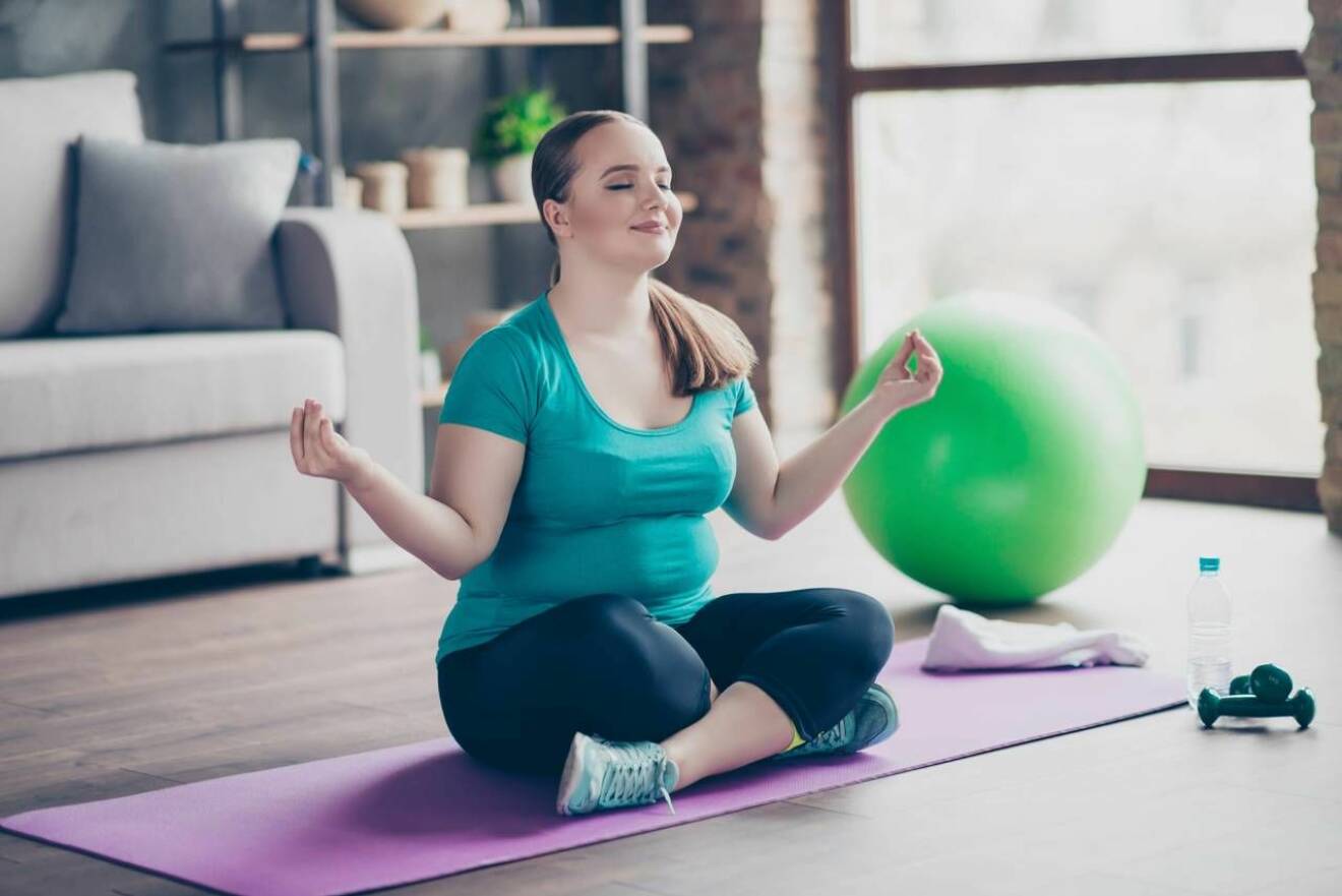 Kroppspositiv kvinna tränar yoga hemma
