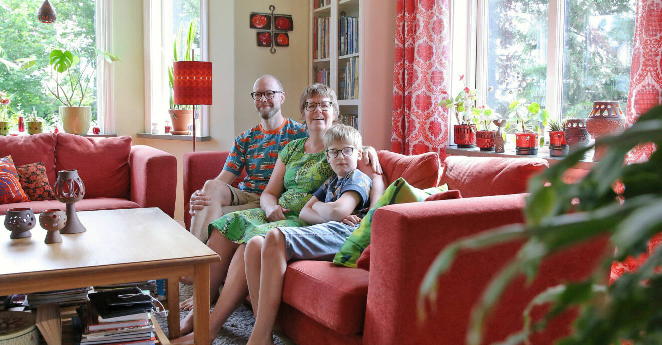 Familjen Holgersson sitter i sin röda soffa.