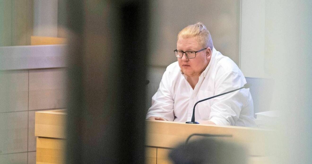 En blond man i vit skjorta, Edvin Gyllensvaan, sitter i en rättegångssal.