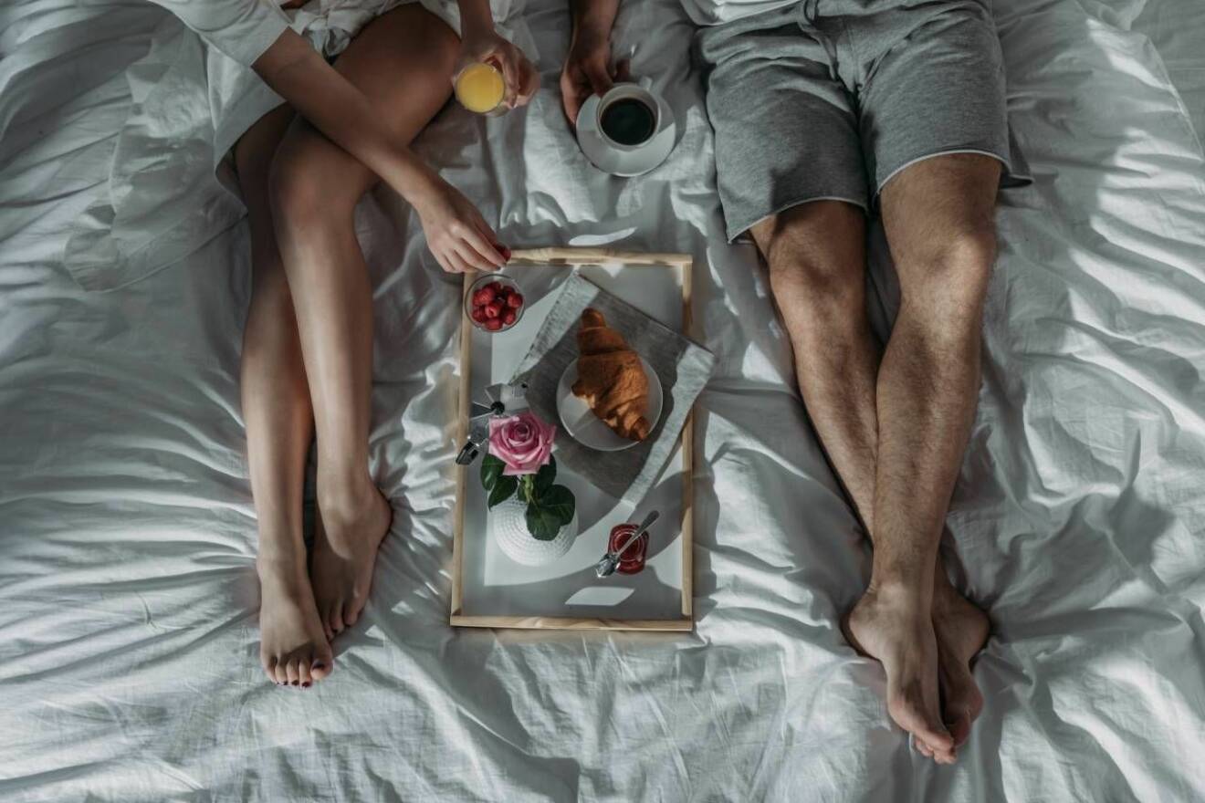 Par äter romantisk frukost i sängen.