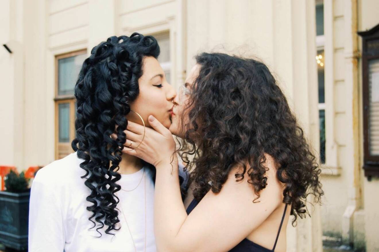 Två kvinnor kysser varandra 