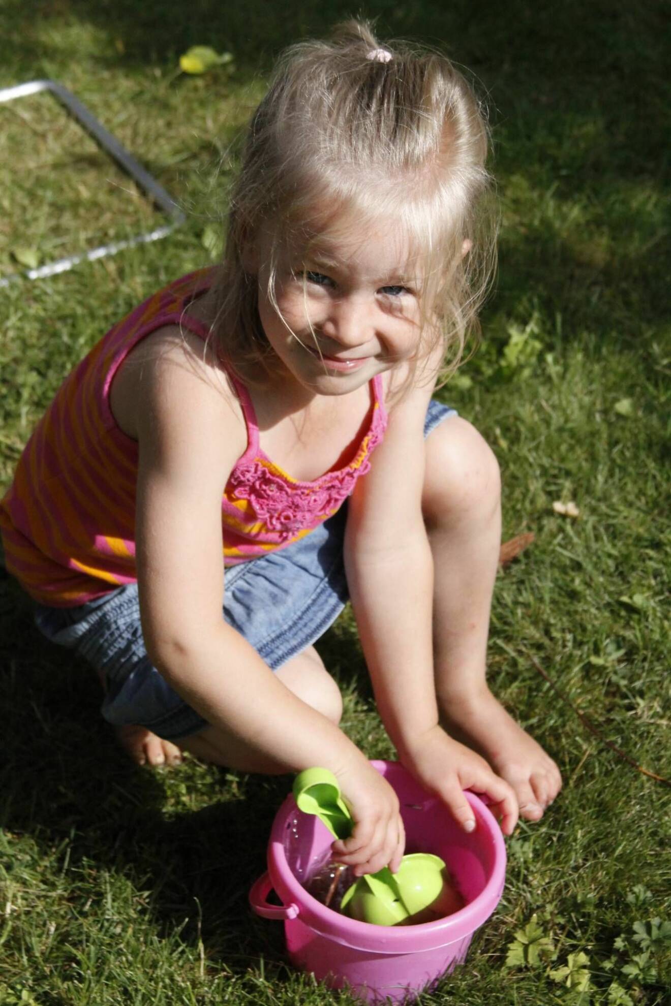 Carolinas dotter Anna leker på gräsmatta 