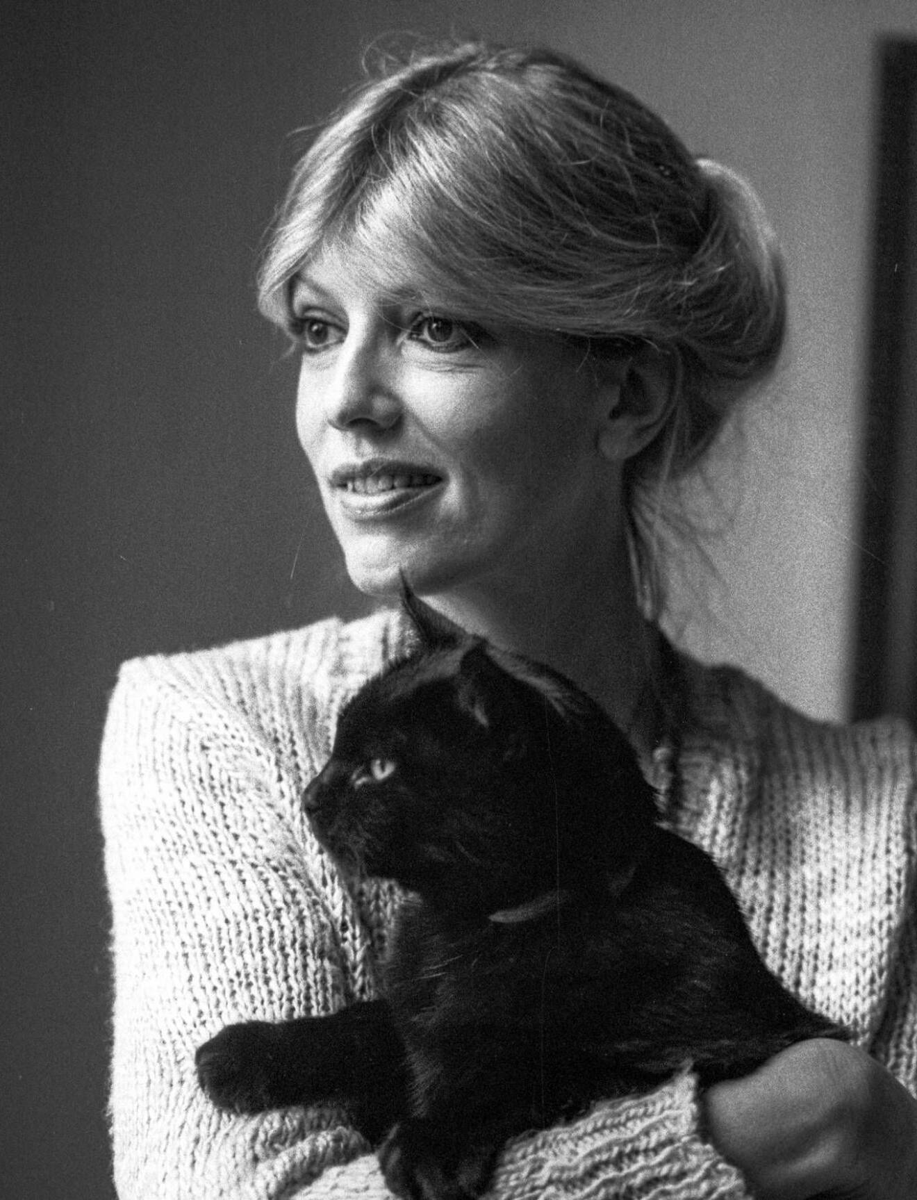 Suzanne 1984 med en katt i sin famn. 