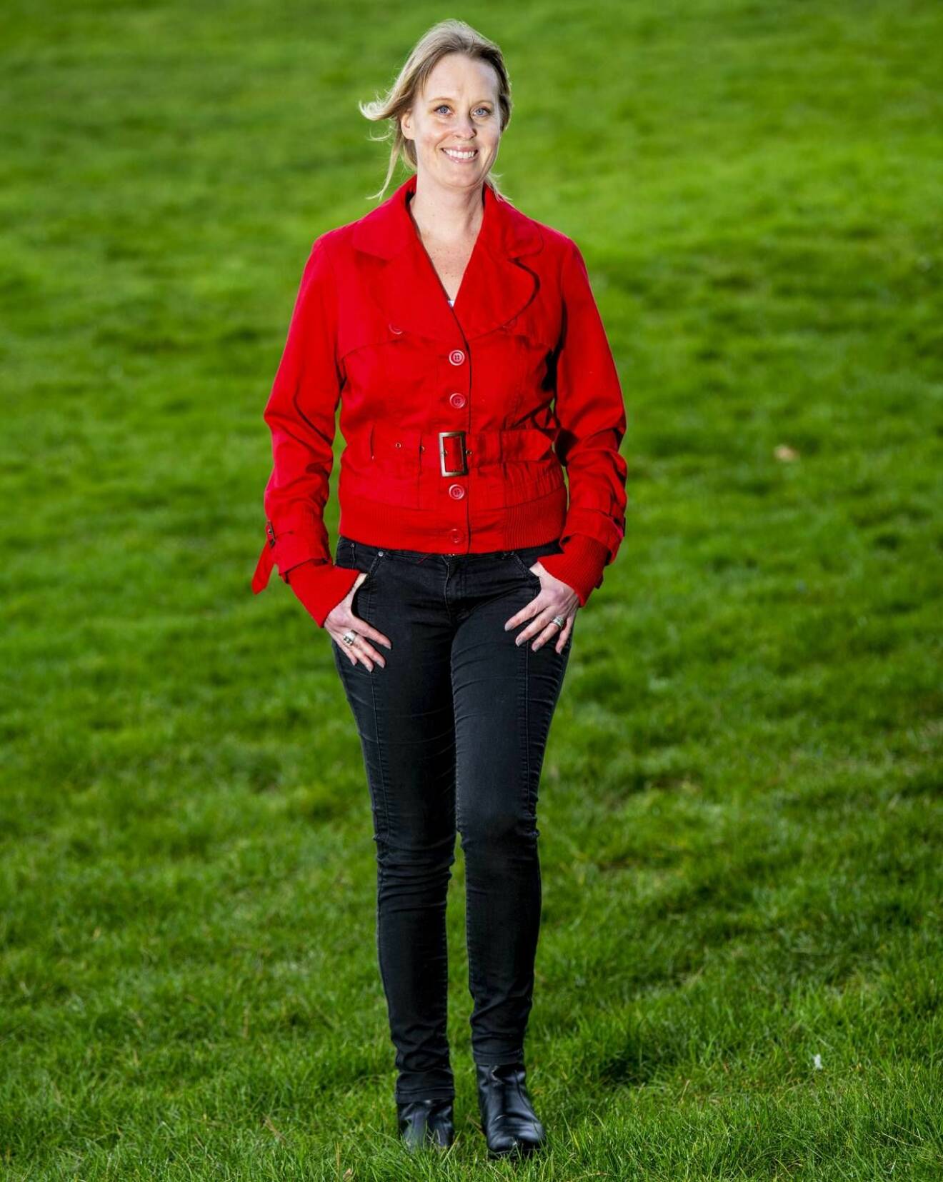 Nathalie, klädd i röd jacka, på promenad i gräset