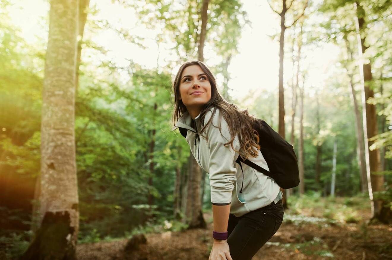 Kvinna vandrar i skog