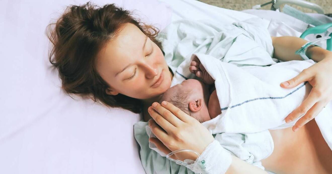 Förlossning, nybliven mamma med sitt nyfödda barn på sjukhus.