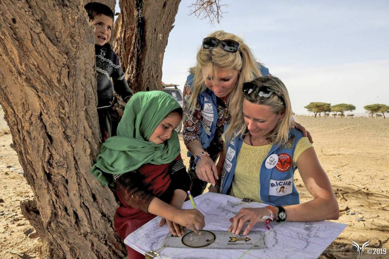 Ett litet barn hjälper kvinnorna att läsa kartan