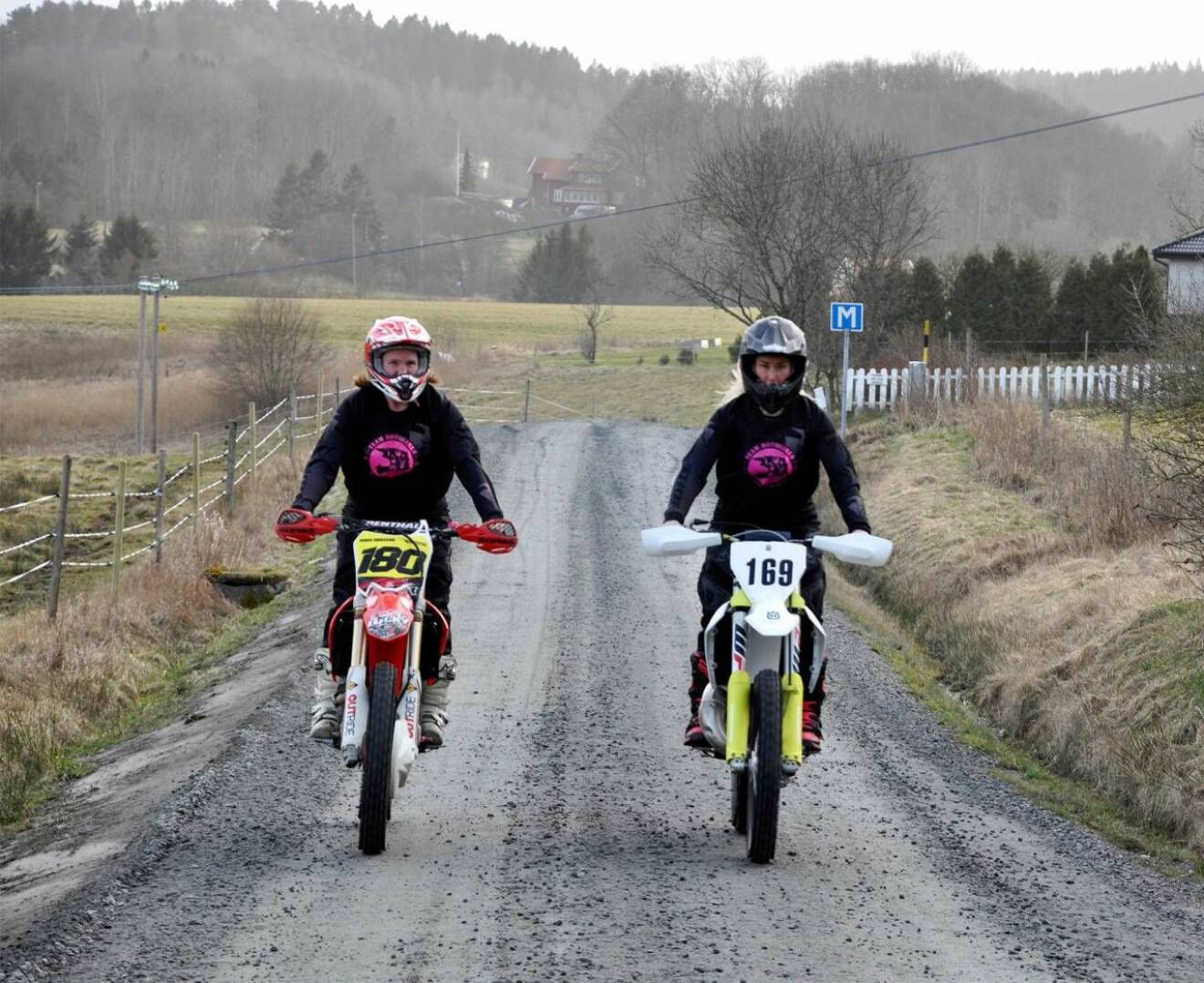 Två kvinnor kör motocross på en grusväg.