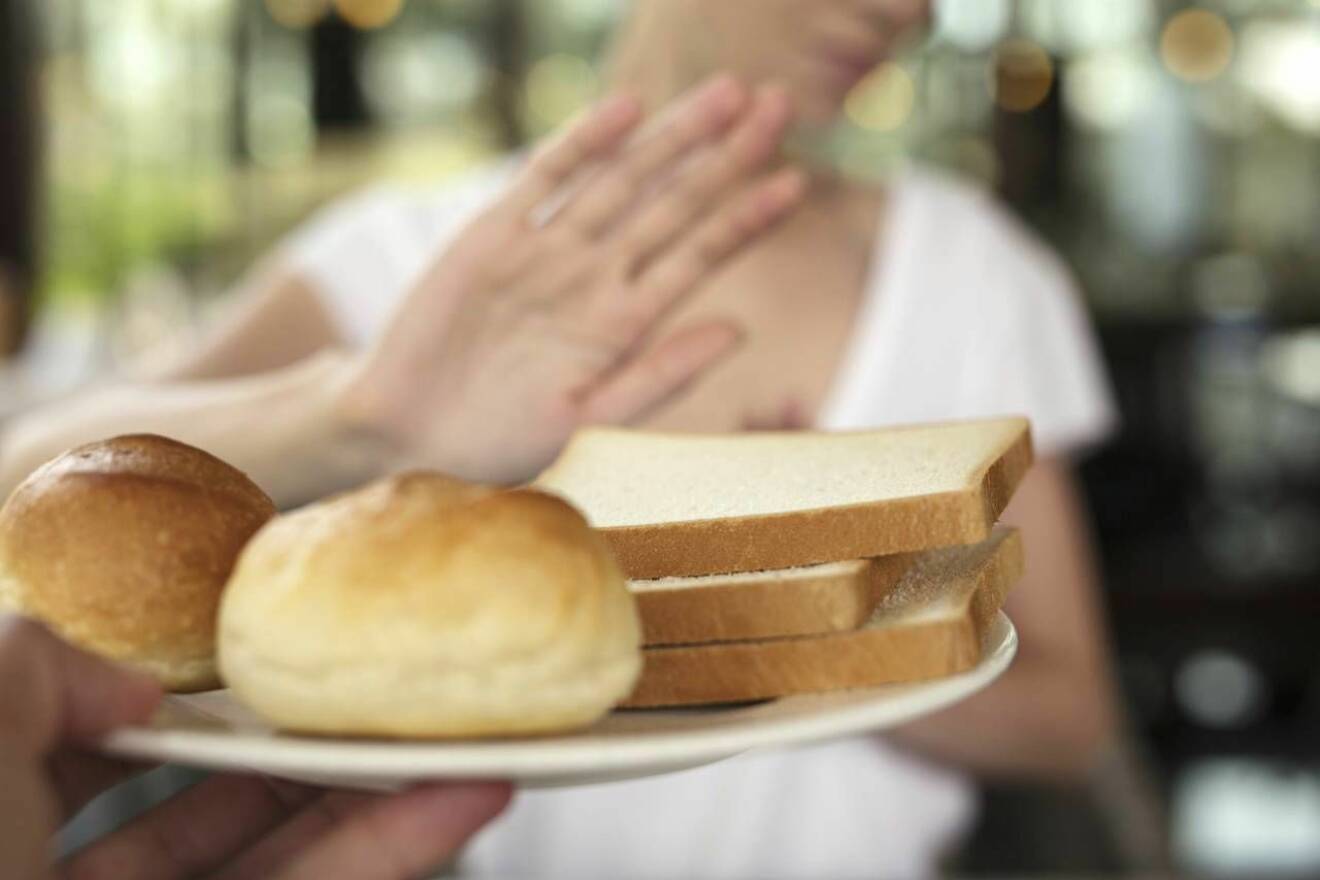 Kvinna tackar nej till glutenfyllda produkter som vitt bröd. 