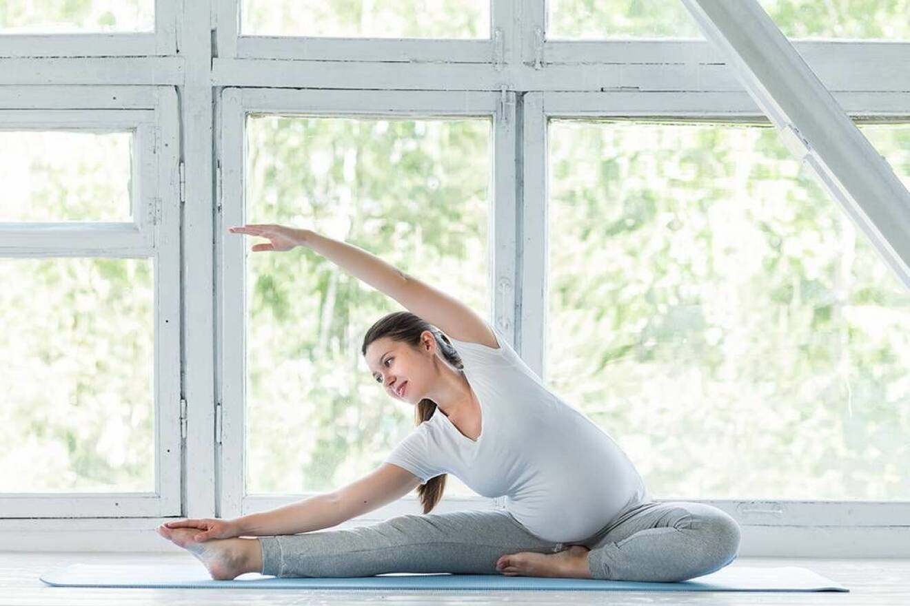 Gravid kvinna gör yoga