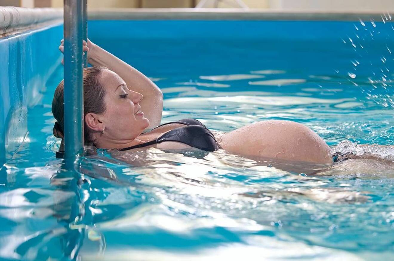 Gravid kvinna gör vattengympa