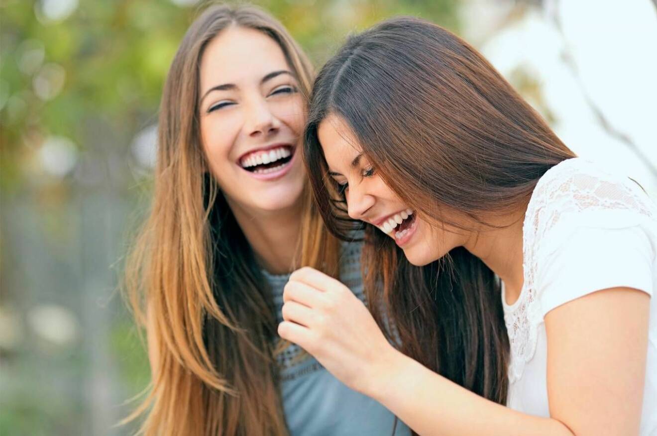 Två unga kvinnor skrattar jättemycket.
