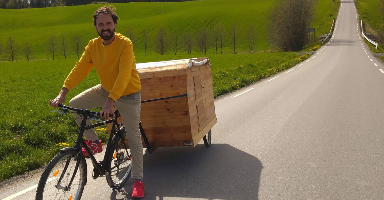 Mario Andrade cyklar med sin hemmabyggda cykelhusvagn.