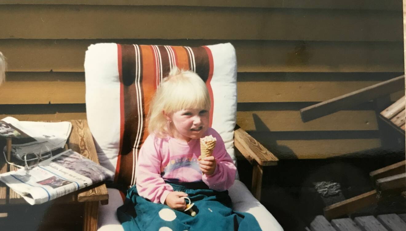 Åsa sitter i en solstol och äter glass.