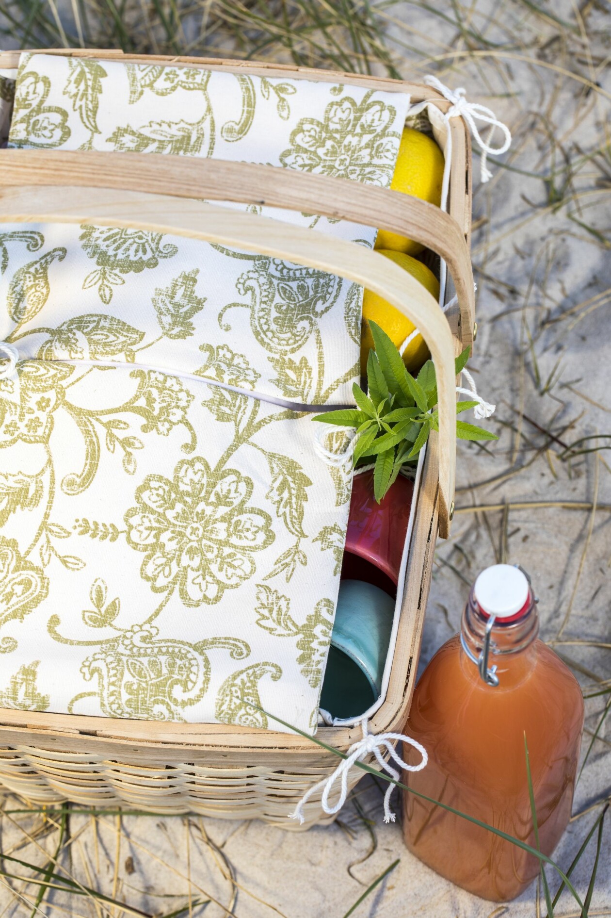 Fickorna på kortsidorna går att knyta ihop till ett praktiskt lock. Picknickkorg med sydd klädsel. Tyg från Ikea och korg från Clas Ohlson