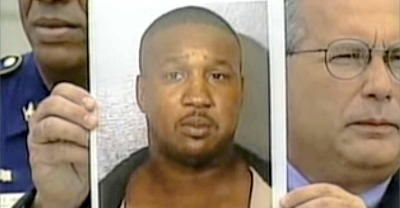 En bild på Derrick Todd Lee hålls upp när han har identifierats som Baton Rouge-mördaren.