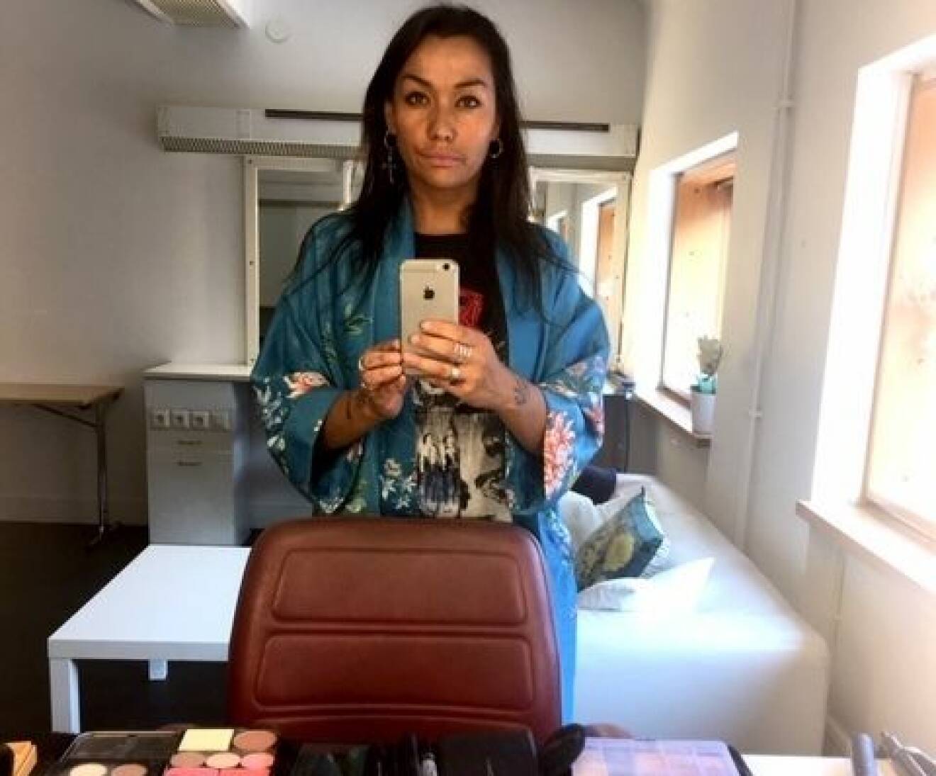 Makeup-artisten Soley Astudottir tar en selfie i spegeln med hjälp av sin iphone.