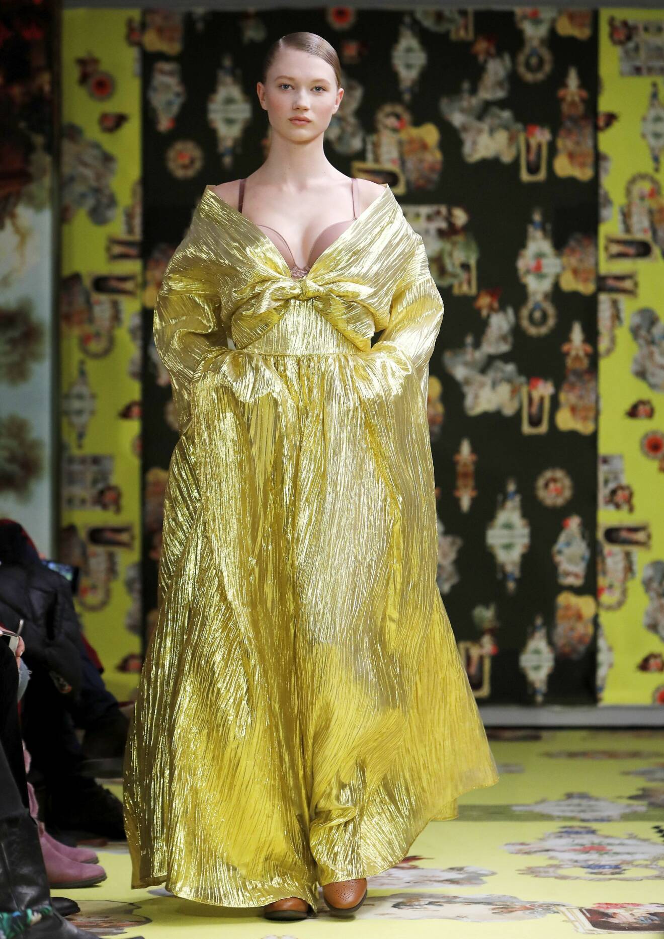 En modell i en gulskimrande klänning av Maxjenny Forslund.