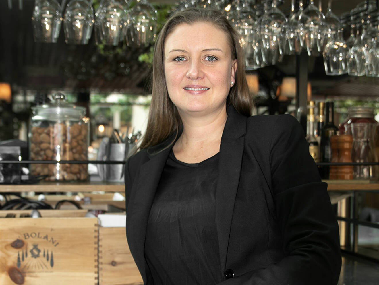 Anna Karlsson Asperén står lutad mot en disk inne på sitt jobb, restaurang Trattorian i Stockholm.