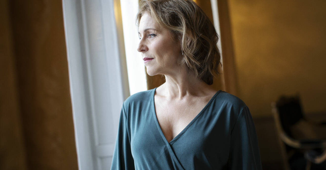 Helen Sjöholm tittar ut genom ett fönster inne på Grand hotel i Stockholm.