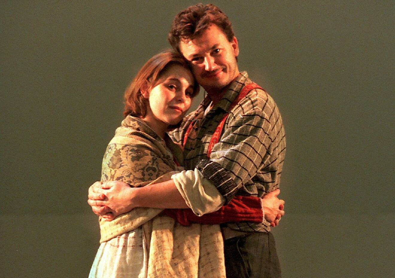 Helen Sjöholm som Kristina och Anders Ekborg som Karl Oskar i musikalen Kristina från Duvemåla. De kramas och tittar in i kameran.