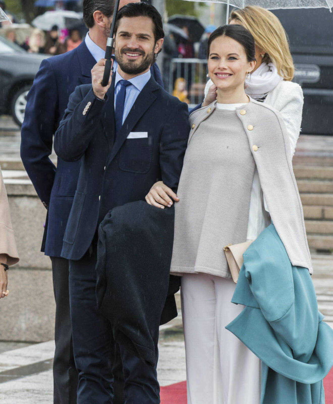Prins Carl Philip och prinsessan Sofia ute i regnet.