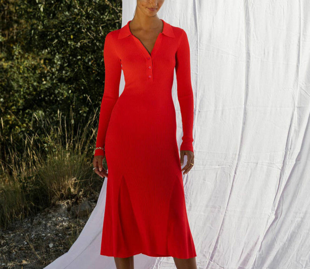 Kvinna i en röd stickad klänning.