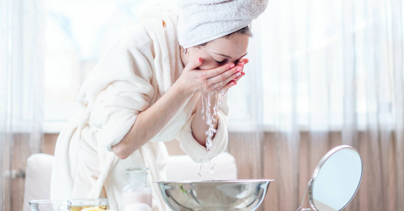 En kvinna som tvättar ansiktet iklädd handdukar som kanske borde tvättas.