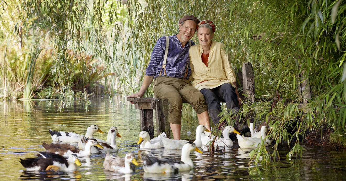 Pressbild från nya säsongen av Mandelmanns gård med premiär i januari 2021. Gustav och Marie Mandelmann sitter på bryggan och i vattnet simmar ankor.