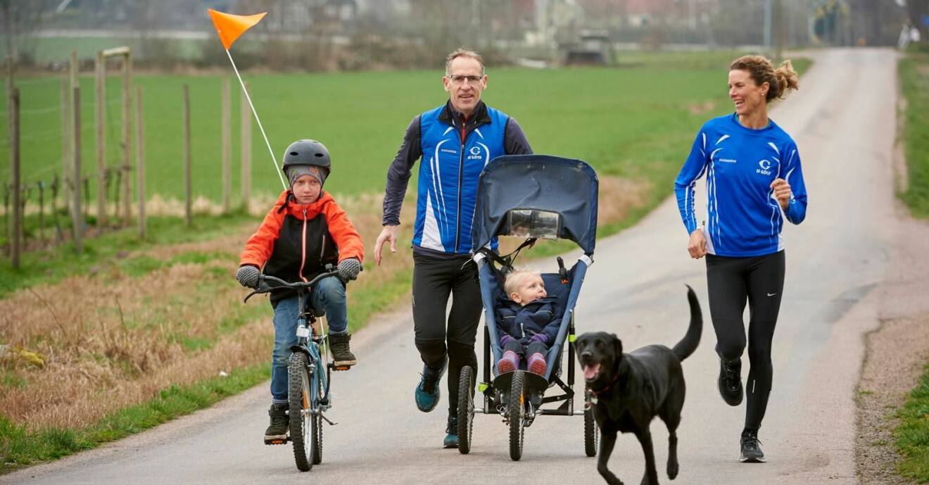 Hela familjen är ute och motionerar: Storebror Simon cyklar och lillebror Dennis sitter i vagn medan pappa Sven och mamma Emma springer.