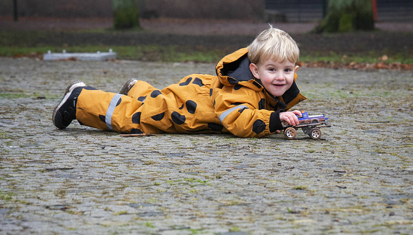 Treåriga Theodore Andersson leker med en bil på marken i Slottsparken i Malmö.