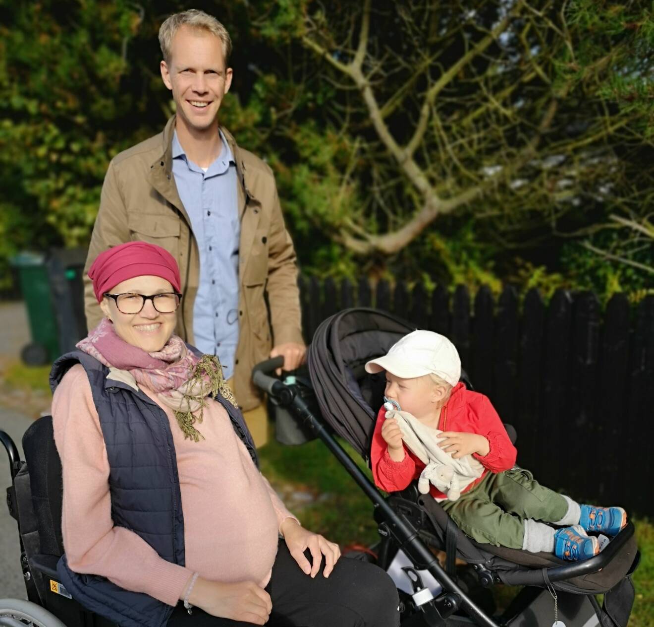 Ebba Hjertstedt i rullstol tillsammans med maken Martin och dottern Leonore.