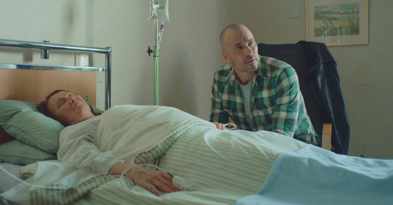 Martin Stenmarck spelar rollen Danne i Lyckoviken säsong 2 och sitter här bredvid sin mammas sjuksäng. Mamma Ingrid spelas av Anna Söderling.
