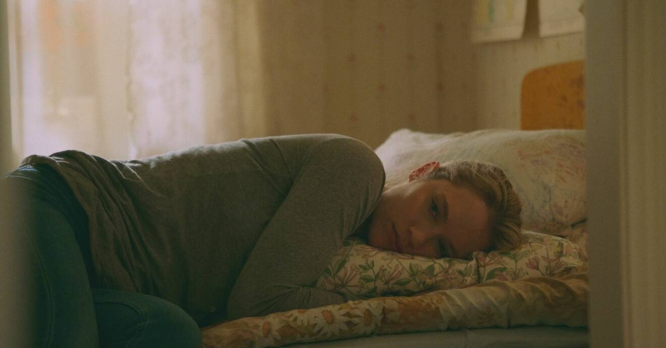 Disa Östrand, som spelar Johanna i säsong två av Lyckoviken, ligger på en bäddad säng.
