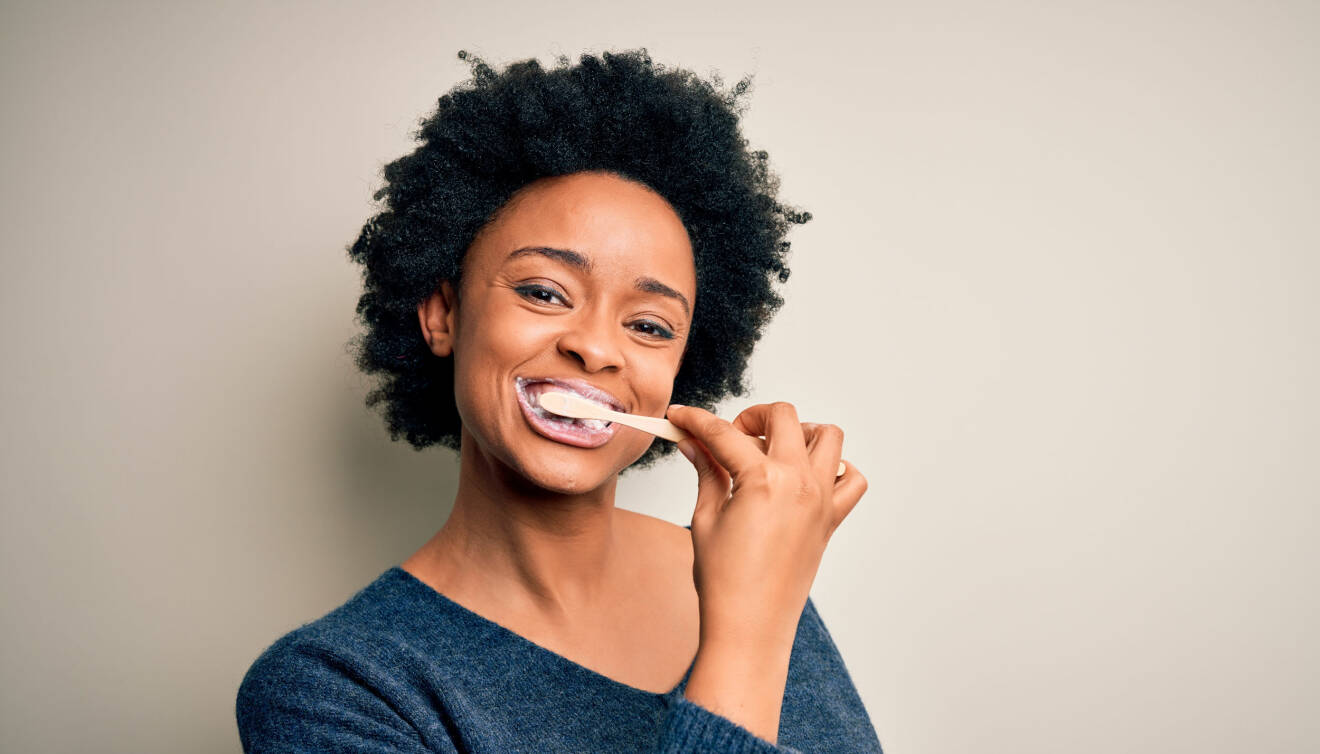 En kvinna borstar tänderna för att få bort plack och orenheter.